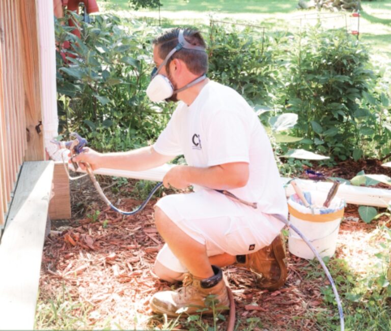 A man sprays paint while wearing an N95 mask for protection